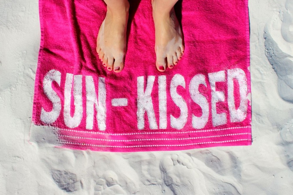 sun-kissed-pink-towel-feet-on-the-beach