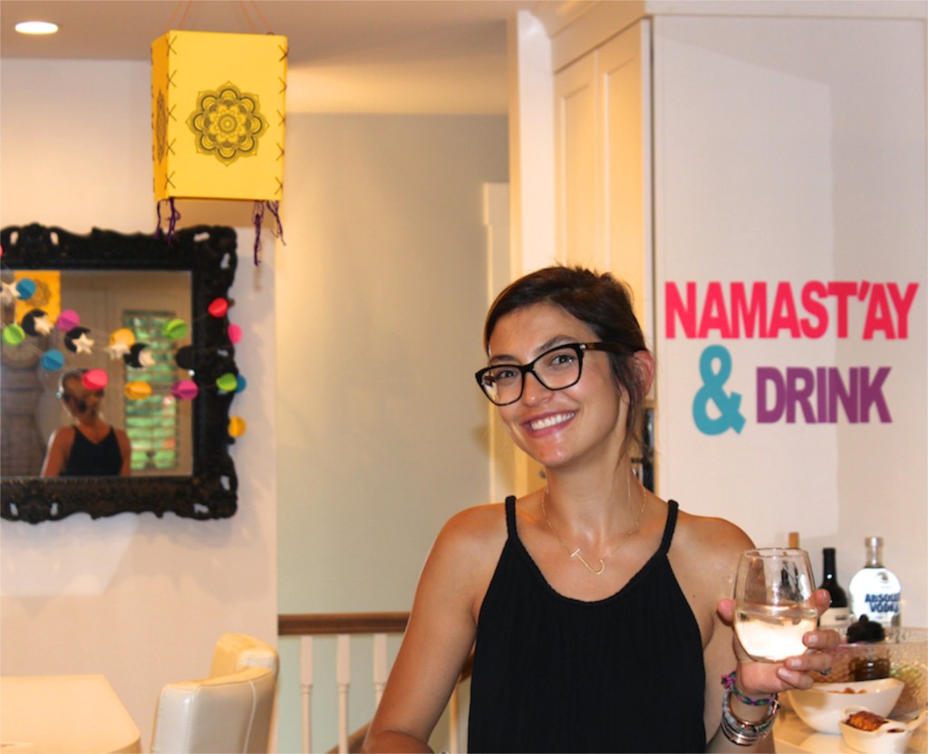 girl-holding-a-glass-of-wine-at-a-party-namastay-and-drink